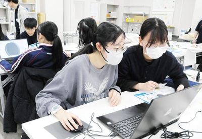 写真:大学生のサポートを受けながらパソコンを操作する参加者