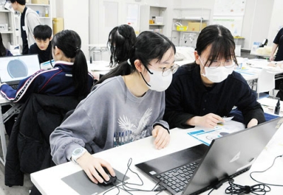 写真:大学生のサポートを受けながらパソコンを操作する参加者