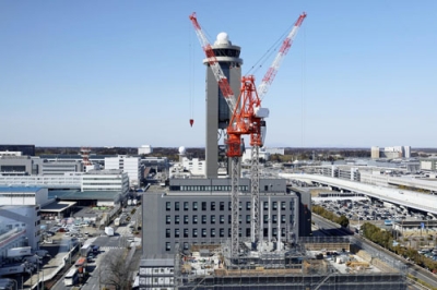 写真：建設工事が進む新管制塔（手前）と現管制塔（奥）＝２月、成田空港