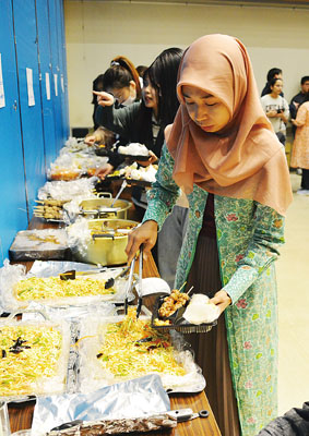 写真：各国の料理を盛り付ける参加者たち