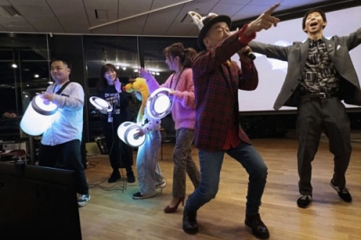 写真：イベントで歌うかしわ哲さん（右から２人目）と「ハグドラム」などを演奏する参加者＝２０２５年１２月、東京都品川区