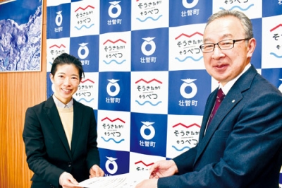 写真：地域おこし協力隊の辞令を受け取る黒田さん（左）