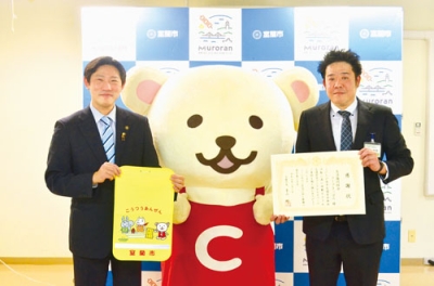 写真:室蘭市内の新入学児童へランドセルカバーを贈る松岡運営部長