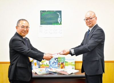 写真：図書寄贈の目録を渋川教育長（左）に手渡す滝澤会長