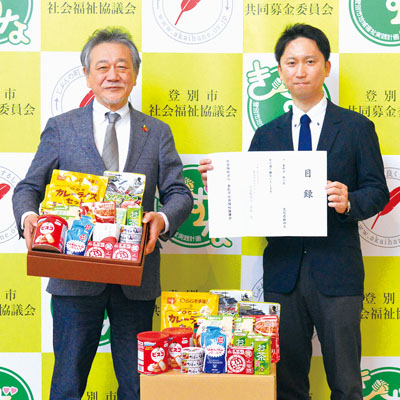 写真:仲川会長(左)に食料品を手渡す有吉さん