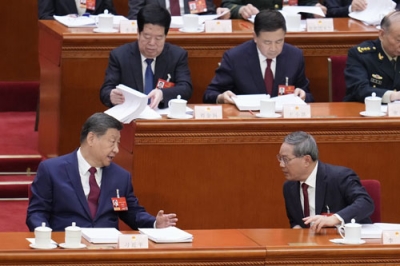 写真:中国全人代で李強首相(手前右)と言葉を交わす習近平国家主席=5日、北京の人民大会堂(共同)