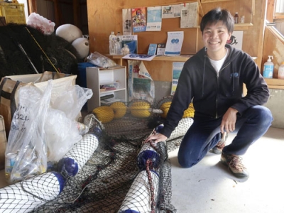 写真：開発した河川のごみ回収装置と写真に納まる室谷雄作さん＝２月、香川県小豆島町