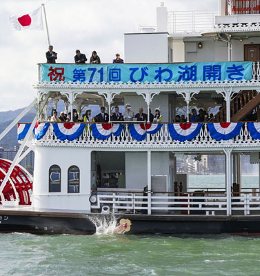 写真：「びわ湖開き」で、遊覧船から湖に投げ入れられる「黄金の鍵」＝７日午前、大津市沖