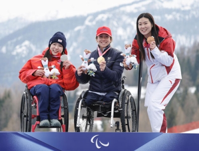 写真：女子スーパー大回転座位の表彰式で笑顔を見せる（左から）銀メダルの村岡桃佳、金のアウドレイ・パスカルセコ、銅の劉思彤＝コルティナダンペッツォ（共同）