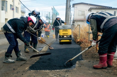 写真：歩道を補修する菱中建設室蘭支店の社員