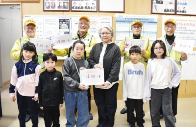 写真：代表児童から手紙を受け取り、笑みを見せる交通安全指導員ら