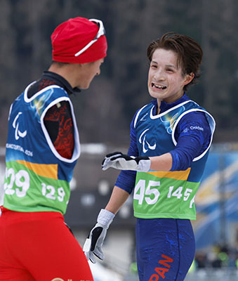 写真：ノルディックスキー距離男子１０キロ立位のゴール後、健闘をたたえ合う川除大輝＝１１日、イタリア・テーゼロ（共同）