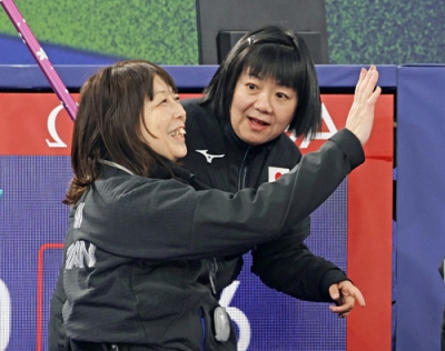 写真：車いすカーリングのイタリア戦で勝利し、笑顔の小川亜希。右は飯野明子コーチ＝コルティナダンペッツォ（共同）