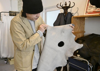 写真：穴の開いたシカの革を手にする入舩郁也さん＝２月、神戸市中央区