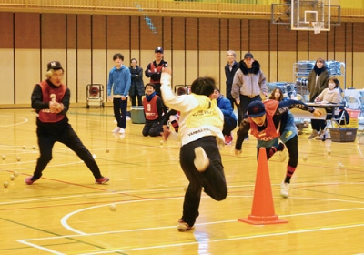 写真：飛んでくるボールをかいくぐりカラーコーンを奪いに走る選手