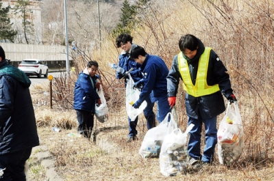 写真：陣屋町の臨港道路に捨てられたごみを拾う市職員
