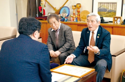 写真：小笠原市長に受賞報告をする田渕さん（右）