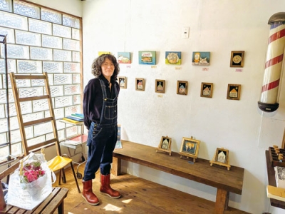 写真：ネコを描いた作品を紹介する坪川さん