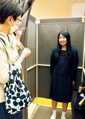 写真：サイズ感や着心地を確認しながら制服を試着する女子生徒＝１７日、洋服の青山ＭＯＲＵＥ中島店