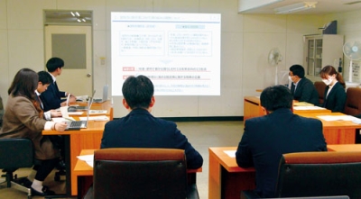 写真：小笠原市長らに脱炭素実現に向けた案を報告する若手職員ら