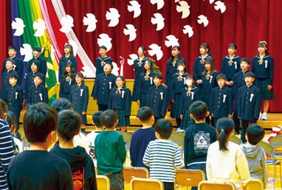 写真：卒業の歌「最後のチャイム」を合唱する卒業生＝１８日、地球岬小