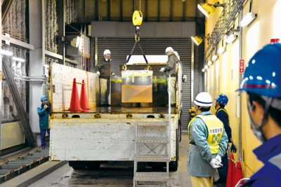 写真：トレーラーに積み込まれるスラグ缶＝１９日午後３時２０分、室蘭市仲町