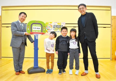 写真:園児にミニバスケットゴールを渡す野口観光の野口常務(左)とレバンガ北海道の折茂社長(右)