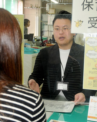写真:窓口で相談に応じる酒本主任