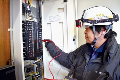 写真：電気回路に異常がないか確認する協会加盟社の従業員