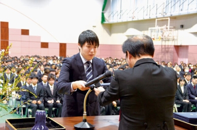 写真：松田学長から学位記を受け取る卒業生代表