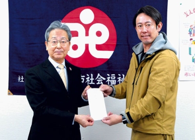 写真：善意を影山会長（左）に手渡す矢野社長