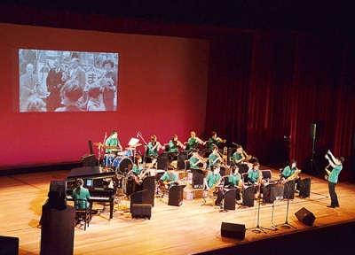 写真:道南バスの歴史を振り返る写真をスクリーンに投影し、演奏する室蘭フラップスジャズオーケストラ