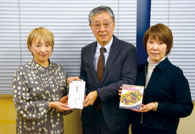 写真:中田実行委員長(左)に寄付の目録を手渡す徳永さん夫妻